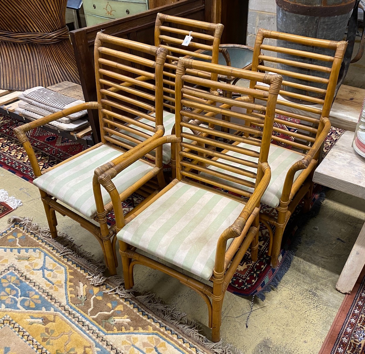 A set of four bamboo elbow chairs with upholstered seats, width 59cm, depth 48cm, height 99cm